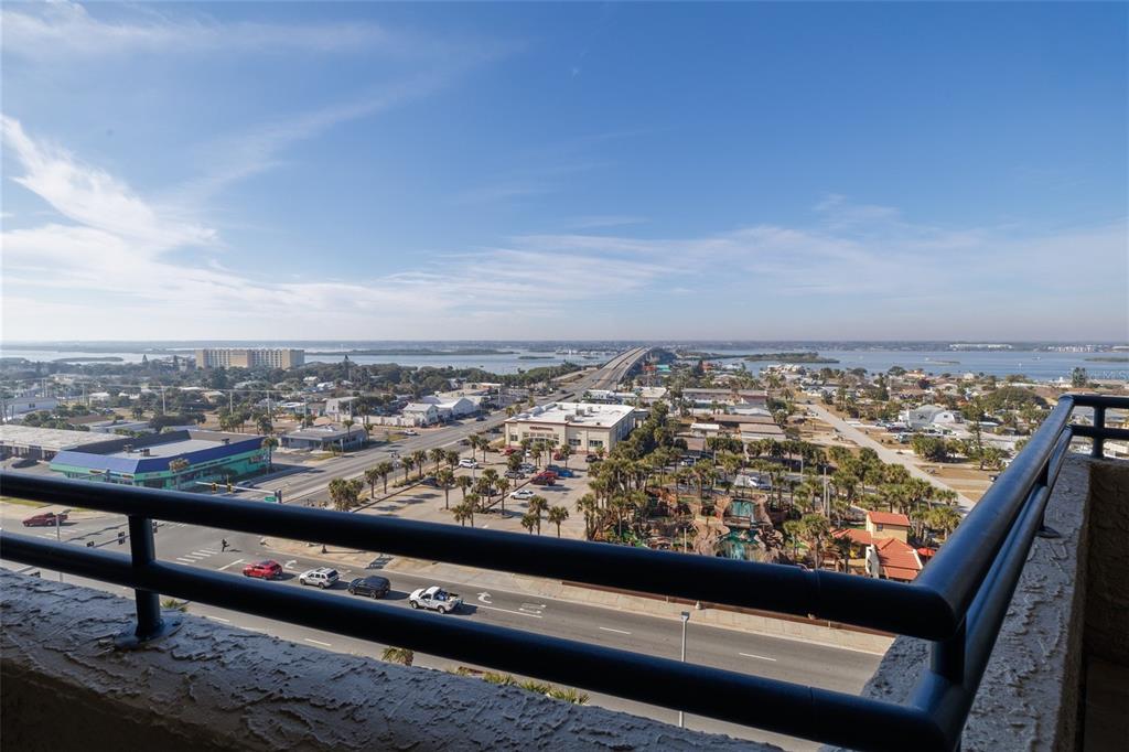 An elevated view from a balcony overlooking a coastal road, bridge, and surrounding buildings — 3425 S ATLANTIC AVENUE UNIT 1102, DAYTONA BEACH, FL