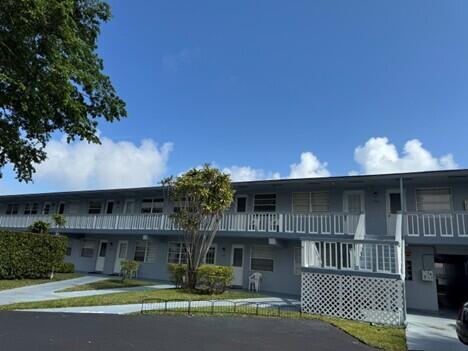 A two-story apartment building with a white balcony railing and a paved parking lot — 751 Pine Drive # 104, Pompano Beach FL 33060, POMPANO BEACH, FL
