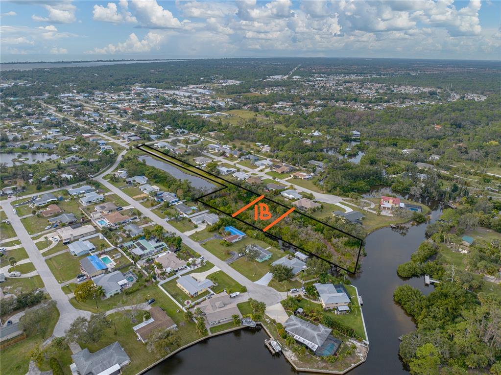 An aerial view shows a vacant, rectangular lot outlined in black near a residential canal — STRATFORD 1B ROAD, ENGLEWOOD, FL