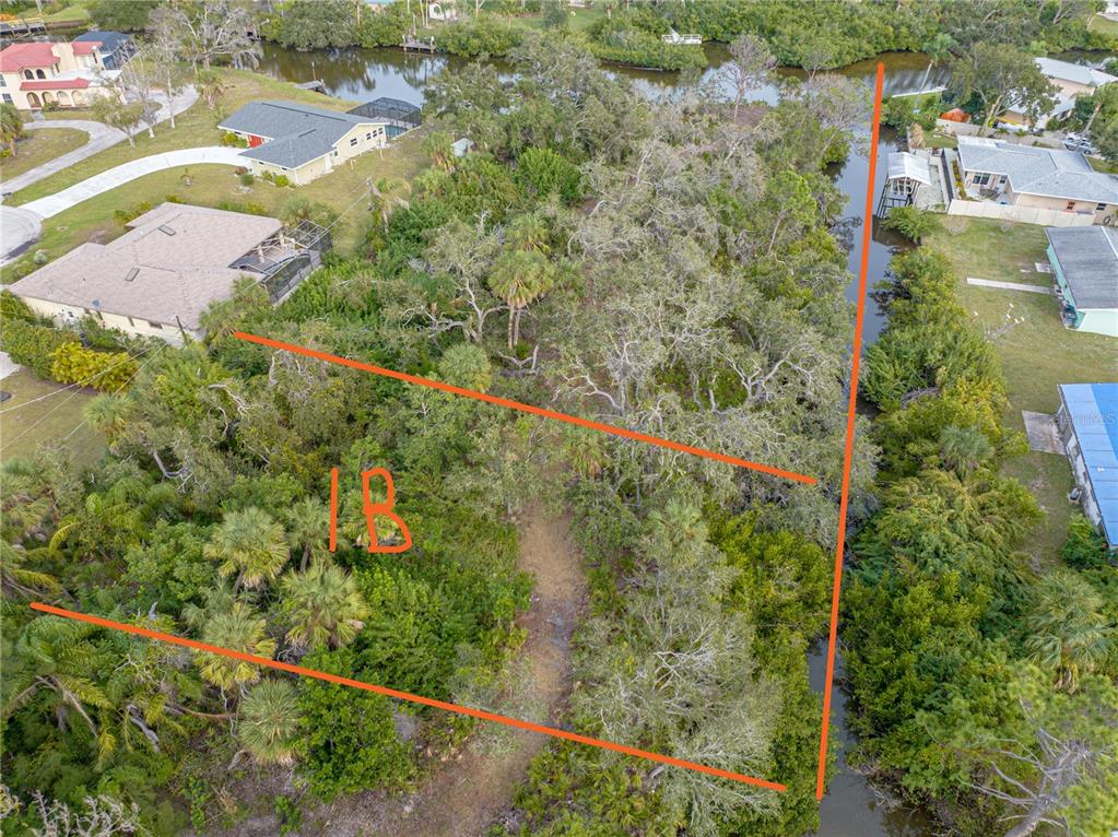 An aerial view shows a wooded, undeveloped lot outlined in orange next to a canal — STRATFORD 1B ROAD, ENGLEWOOD, FL