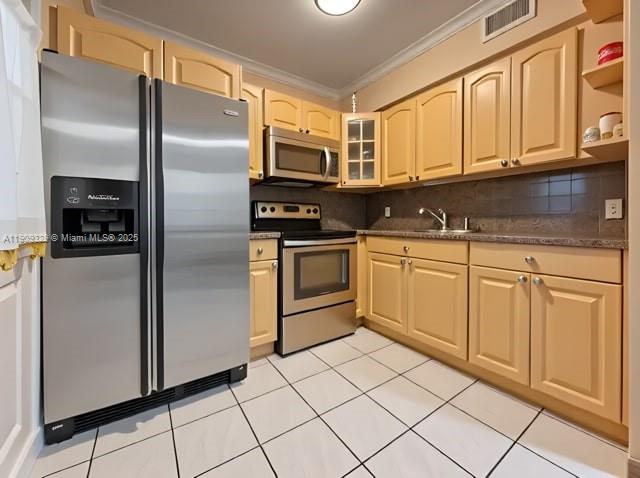 A kitchen features light wood cabinets, stainless steel appliances, and white tiled flooring — 2701 SW 29th Ave, Miami FL 33133, MIAMI, FL