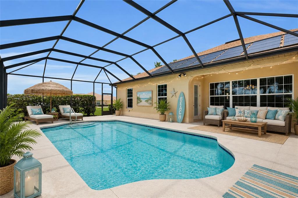 A screened-in patio features a swimming pool, outdoor seating, and a decorative surfboard sign — 9908 SE 67TH AVENUE ROAD, BELLEVIEW, FL
