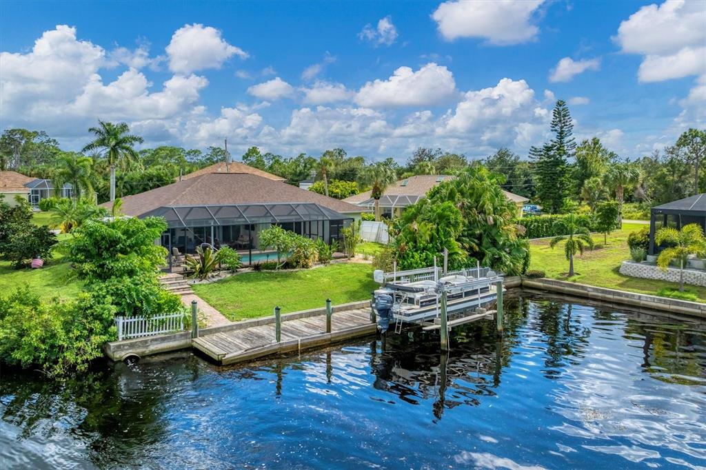 An aerial view of a waterfront house with a screened pool and a boat dock — 2555 DIXON TERRACE, PORT CHARLOTTE, FL