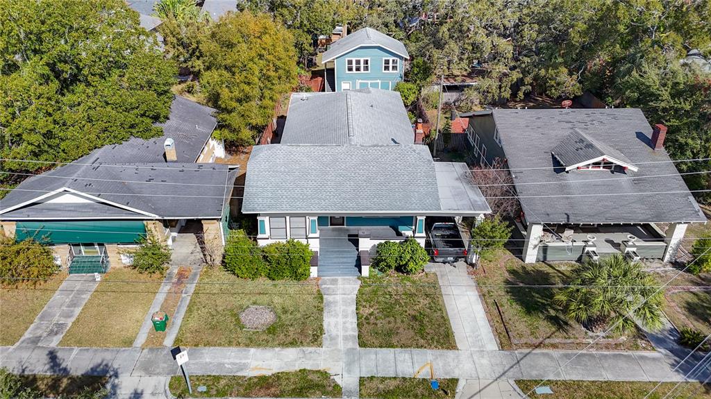 An aerial view shows three houses with driveways and front porches along a residential street — 2105 W SOUTHVIEW AVENUE, TAMPA, FL