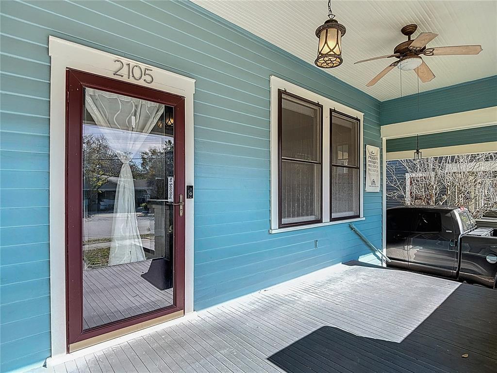 A blue-sided house features a covered front porch with a ceiling fan and light fixture — 2105 W SOUTHVIEW AVENUE, TAMPA, FL