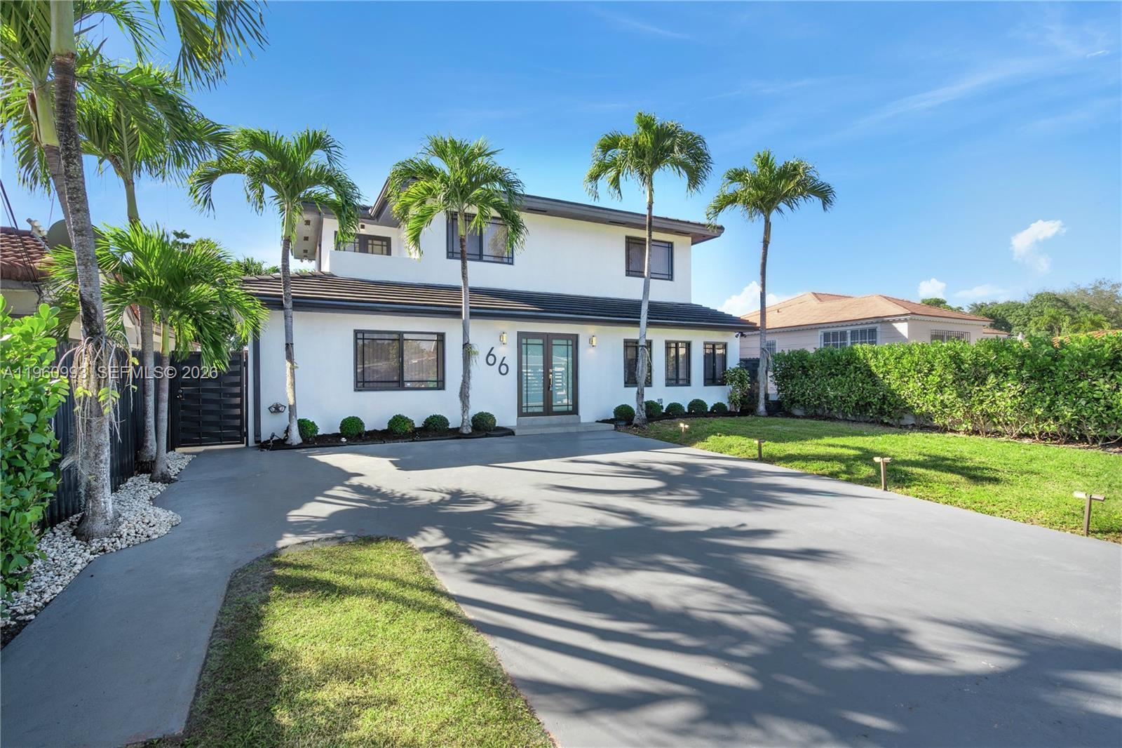 A two-story white house with a gray driveway and palm trees in the front yard — 66 NW 73rd Place, Miami FL 33126, MIAMI, FL