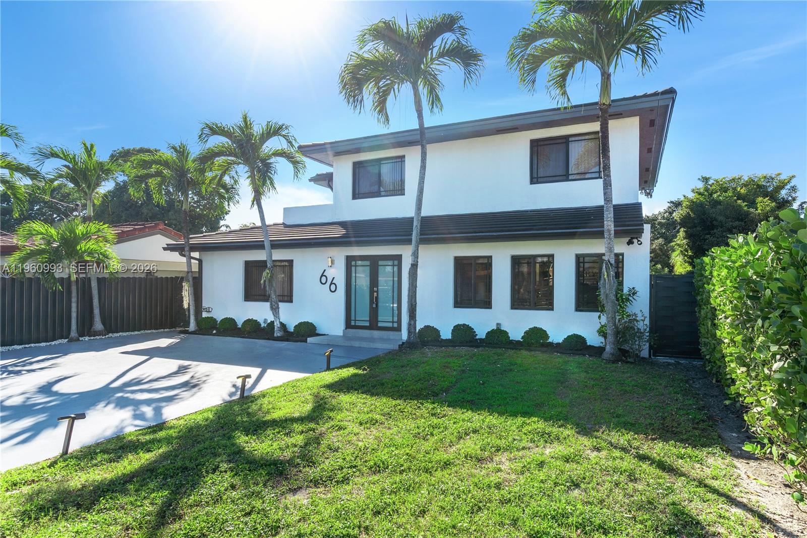 A two-story white house with dark-framed windows and palm trees in the front yard — 66 NW 73rd Place, Miami FL 33126, MIAMI, FL