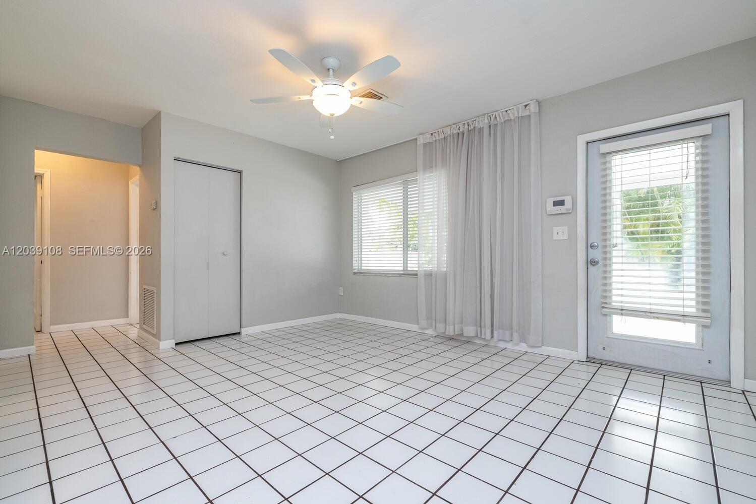 A room with white tiled floors, a ceiling fan, a closet, and a glass door — 1029 NE 113 St, Biscayne Park FL 33161, BISCAYNE PARK, FL