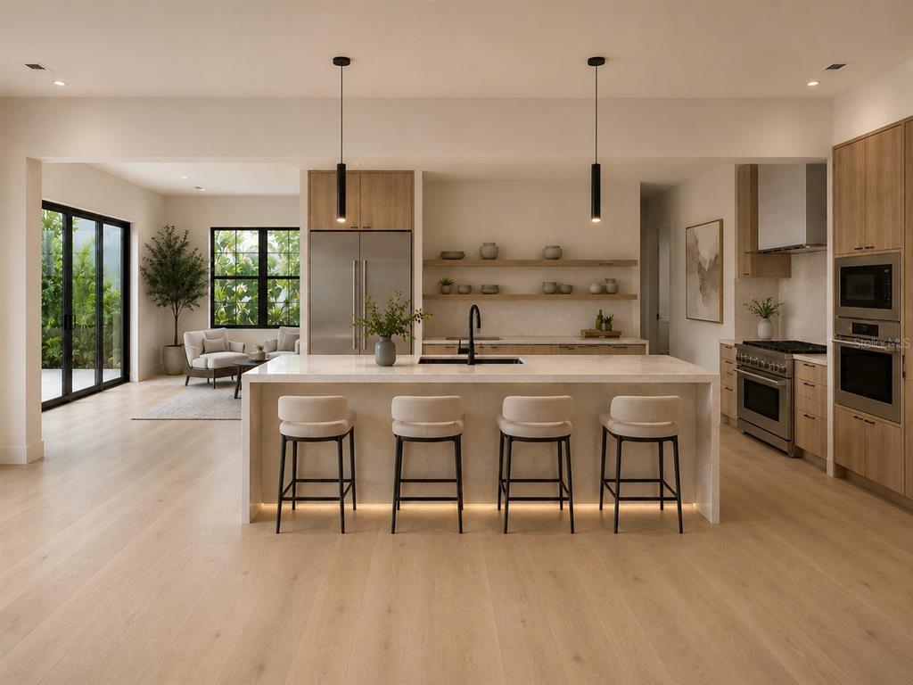 A modern kitchen features a large island with four stools, light wood cabinetry, and stainless-steel appliances — 5020 W HOMER AVENUE, TAMPA, FL