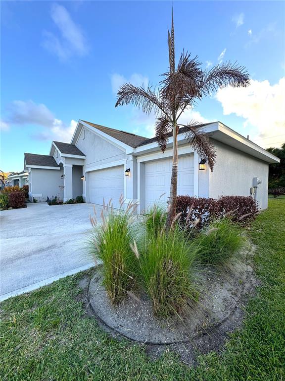 A light-colored house with a two-car garage and a palm tree in the front yard — 5380 LUGO STREET, FORT PIERCE, FL