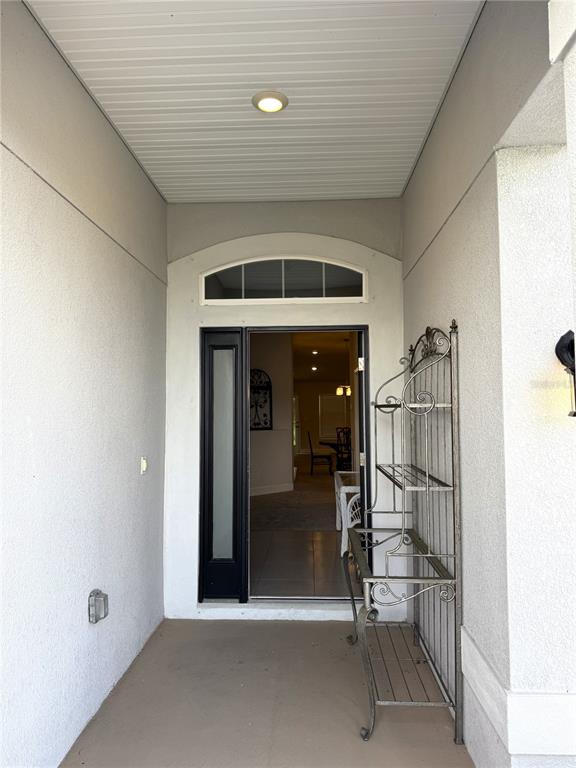 A covered entryway leads to an open front door with a metal shelf nearby — 5380 LUGO STREET, FORT PIERCE, FL