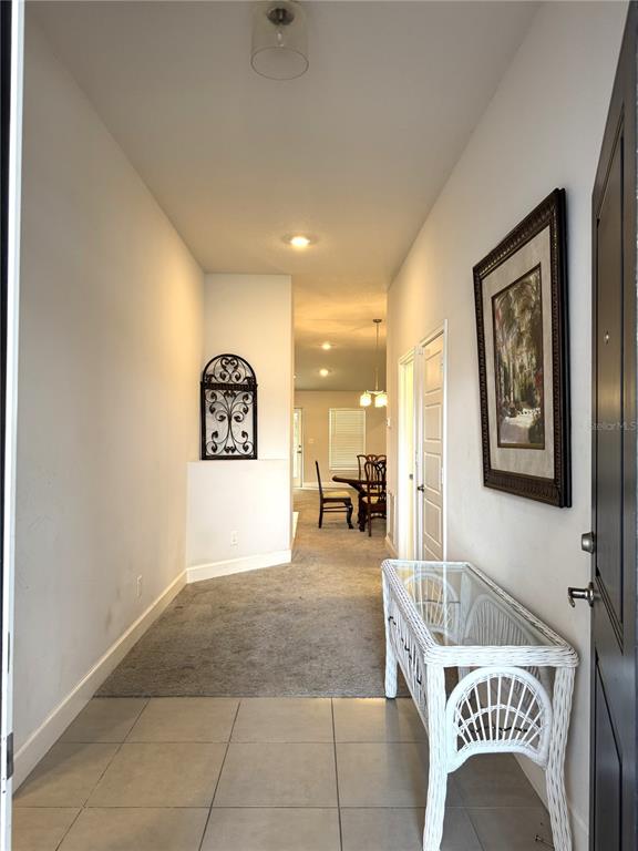 A tiled entryway leads into a carpeted hallway with a white wicker console table — 5380 LUGO STREET, FORT PIERCE, FL