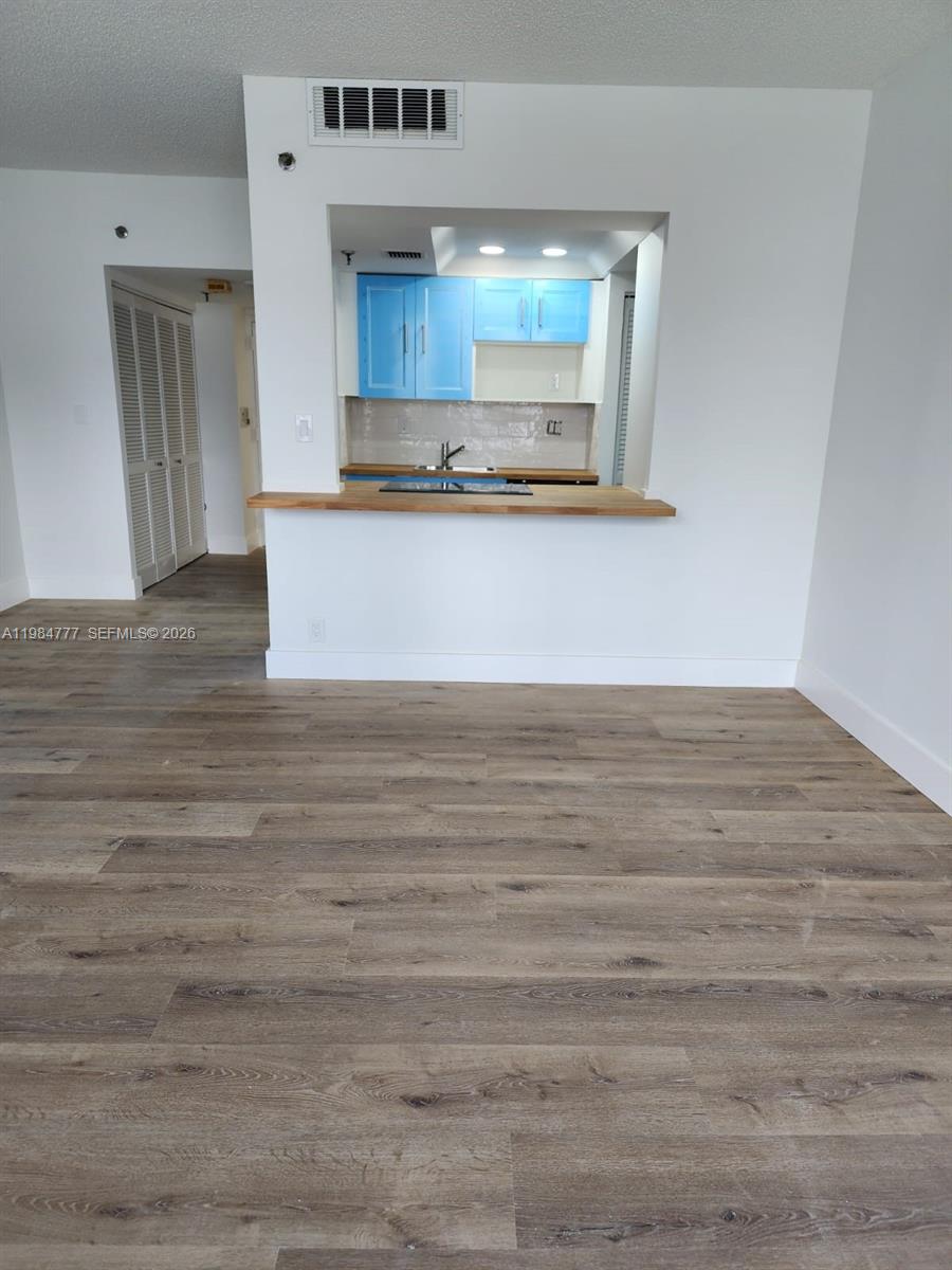 A view of a kitchen with bright blue cabinets and a wooden breakfast bar — 520 Brickell Key Dr # A1517, Miami FL 33131, MIAMI, FL