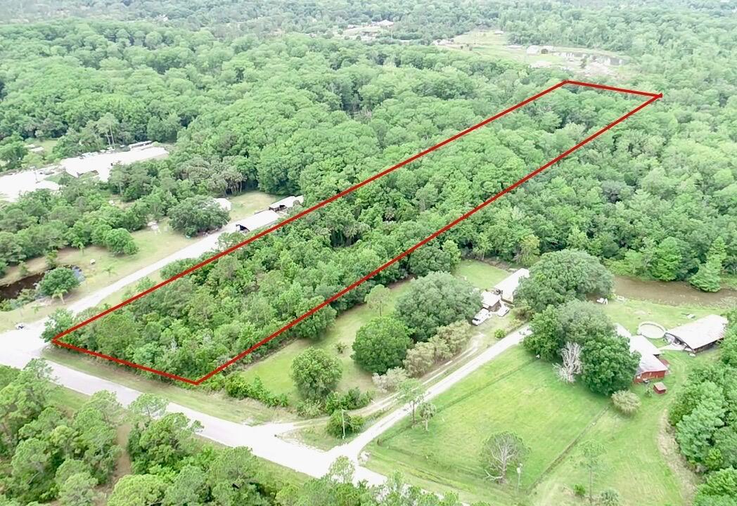 An aerial view shows a rectangular, wooded plot of land outlined in red — 1465 NE 342nd Trail, Okeechobee FL 34972, OKEECHOBEE, FL