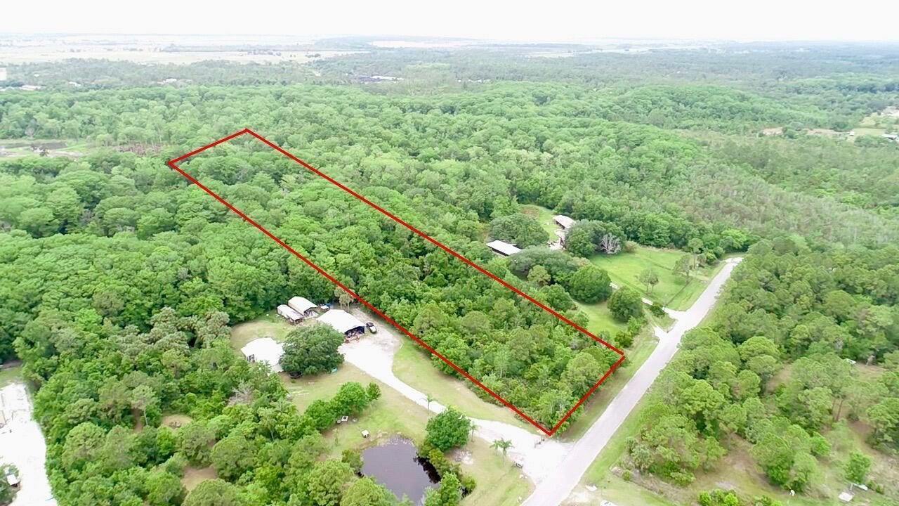 An aerial view shows a rectangular plot of land outlined in red amidst dense forest — 1465 NE 342nd Trail, Okeechobee FL 34972, OKEECHOBEE, FL
