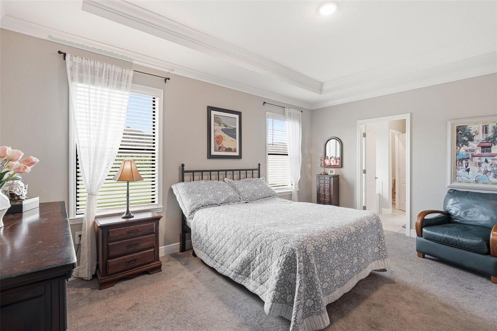 A bedroom features a bed, a dark leather armchair, a nightstand, and two windows — 15240 MILLE FIORE BOULEVARD, PORT CHARLOTTE, FL