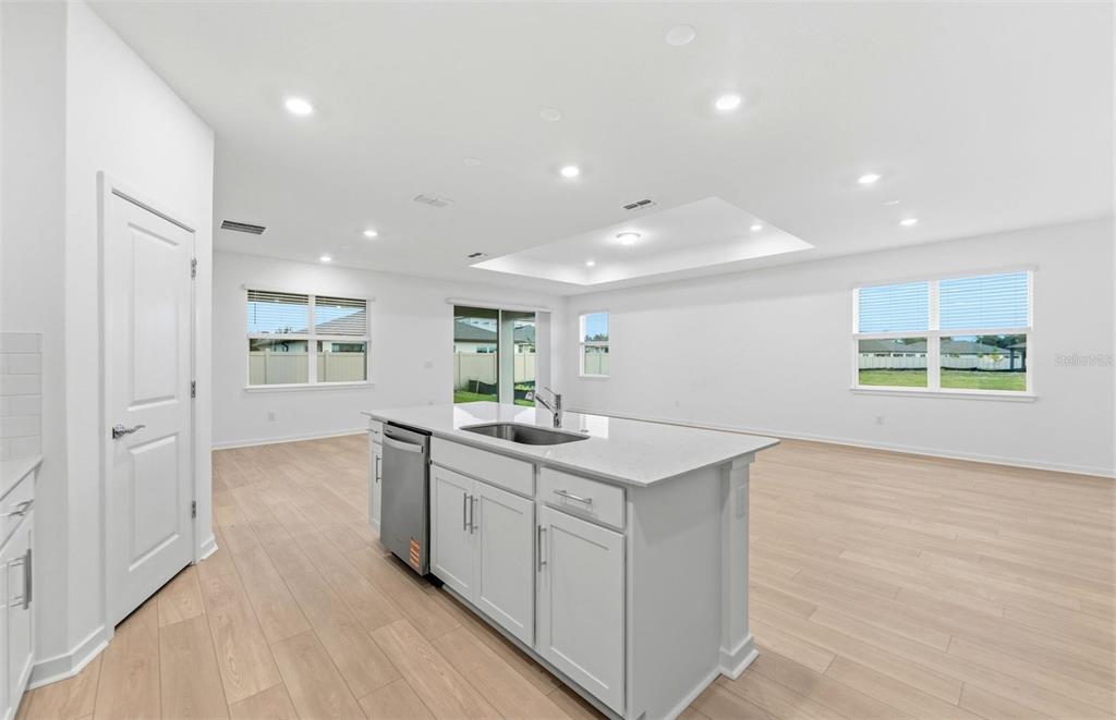 A kitchen island with a stainless steel dishwasher sits in a room with light flooring — 6607 ASBURY BARNES LANE, WESLEY CHAPEL, FL