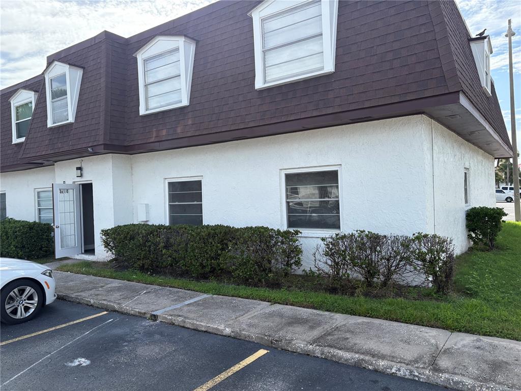 A two-story building with a brown mansard roof and white stucco exterior walls — 9218 TUDOR DRIVE UNIT P101, TAMPA, FL