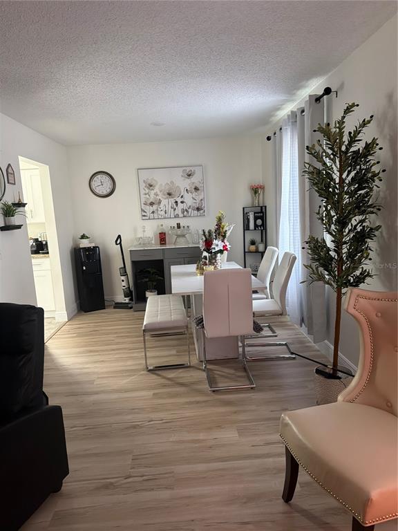 A dining area features a white table, chairs, a bench, and light wood-look flooring — 9218 TUDOR DRIVE UNIT P101, TAMPA, FL