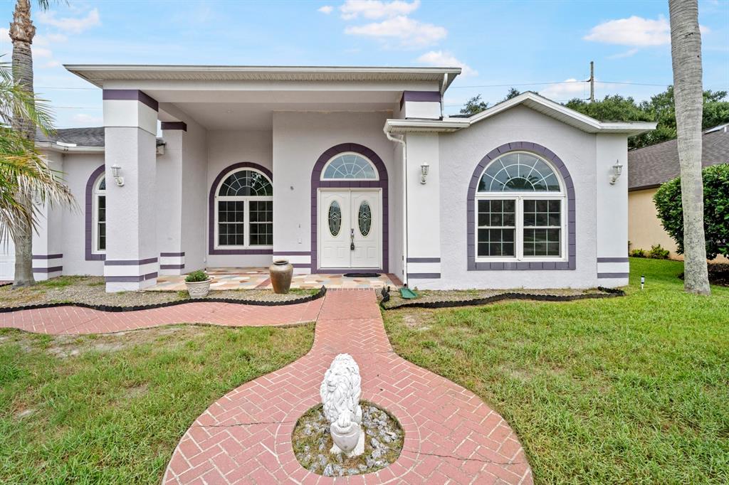 A single-story house with a brick walkway, a lion statue, and a double front door — 2087 WESTBOURNE DRIVE, OVIEDO, FL