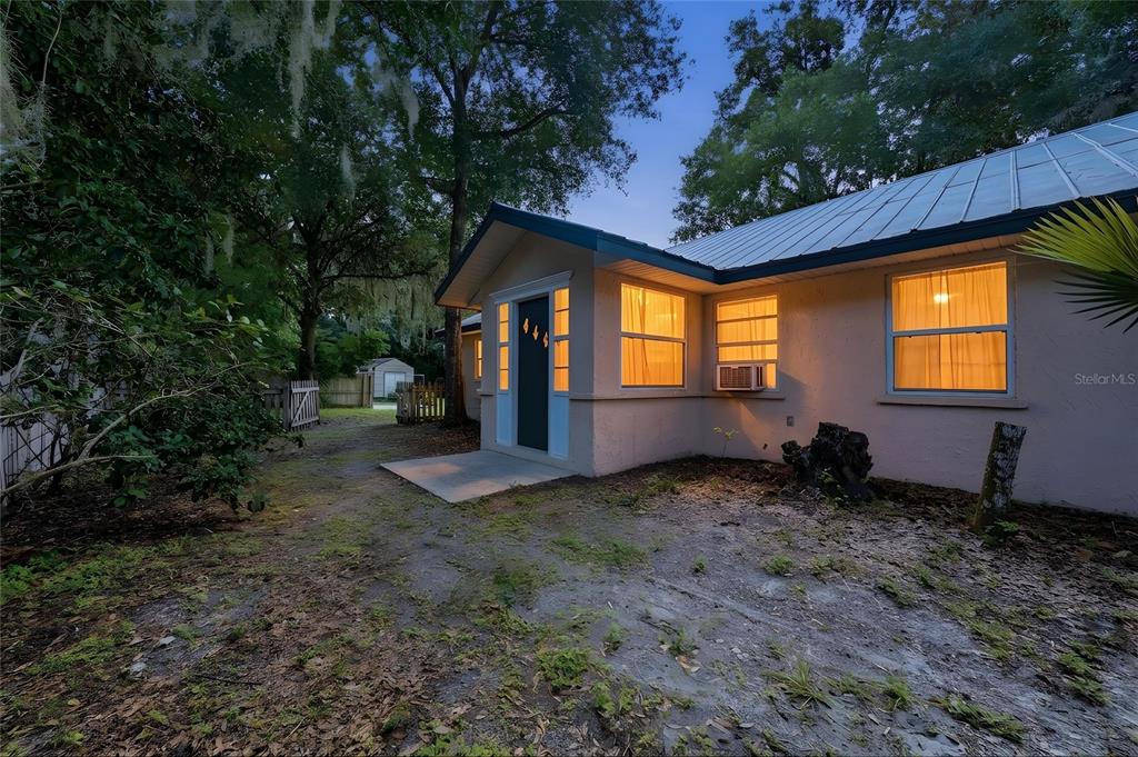 The exterior of a single-story house features a metal roof, stucco walls, and a porch — 3543 N COUNTY ROAD 426, GENEVA, FL