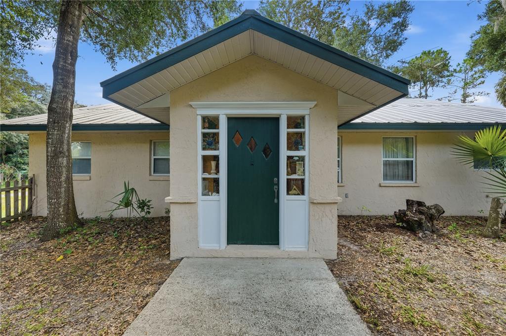 A single-story house with a green front door and a covered entryway — 3543 N COUNTY ROAD 426, GENEVA, FL