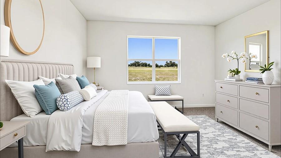 A bright bedroom features a tufted headboard, a dresser, and a window overlooking a field — 4015 NW 44TH CIRCLE, OCALA, FL