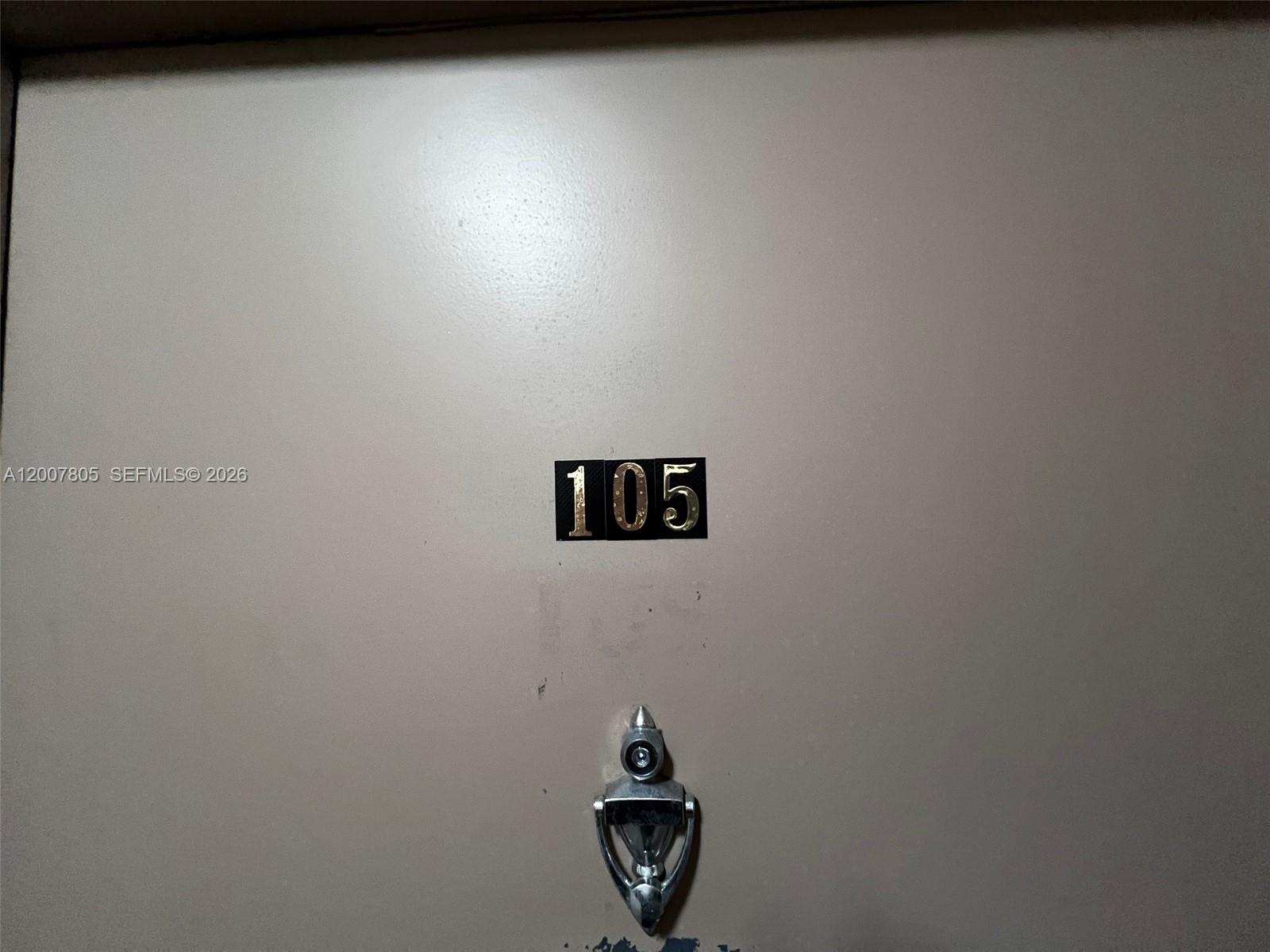A beige door features a metal door knocker and the number 105 — 8411 NW 8th St # 105, Miami FL 33126, MIAMI, FL