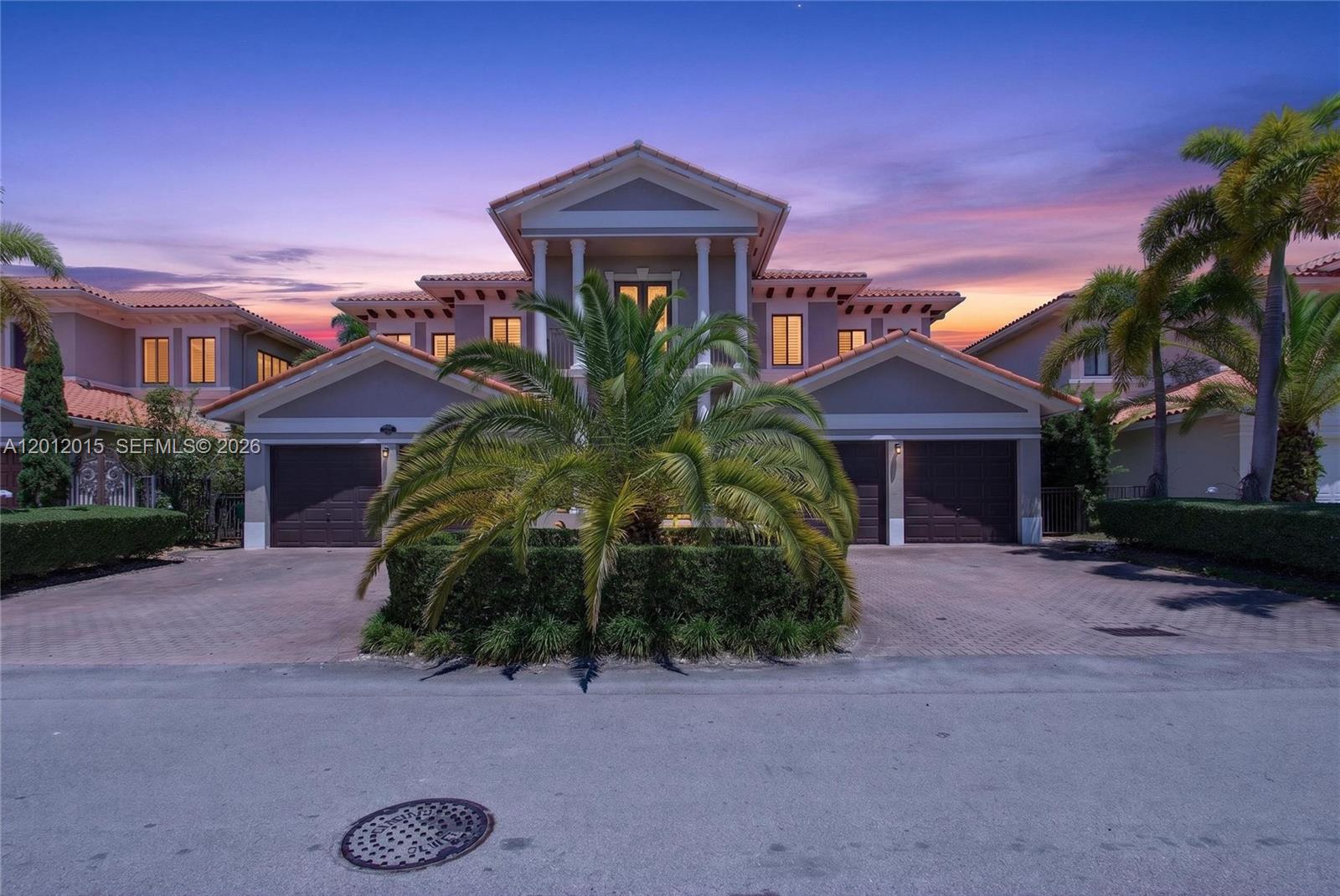 A two-story house with a symmetrical facade, two garages, and a central palm tree — 18841 SW 74th Ct, Cutler Bay FL 33157, CUTLER BAY, FL