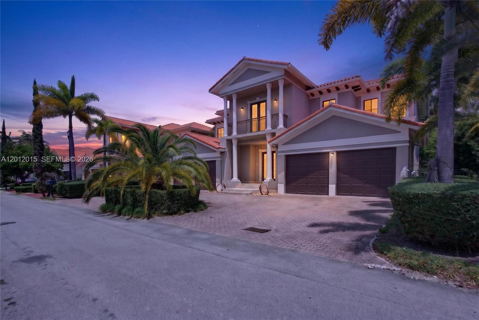 A two-story house with a tiled roof, a three-car garage, and palm trees at dusk — 18841 SW 74th Ct, Cutler Bay FL 33157, CUTLER BAY, FL