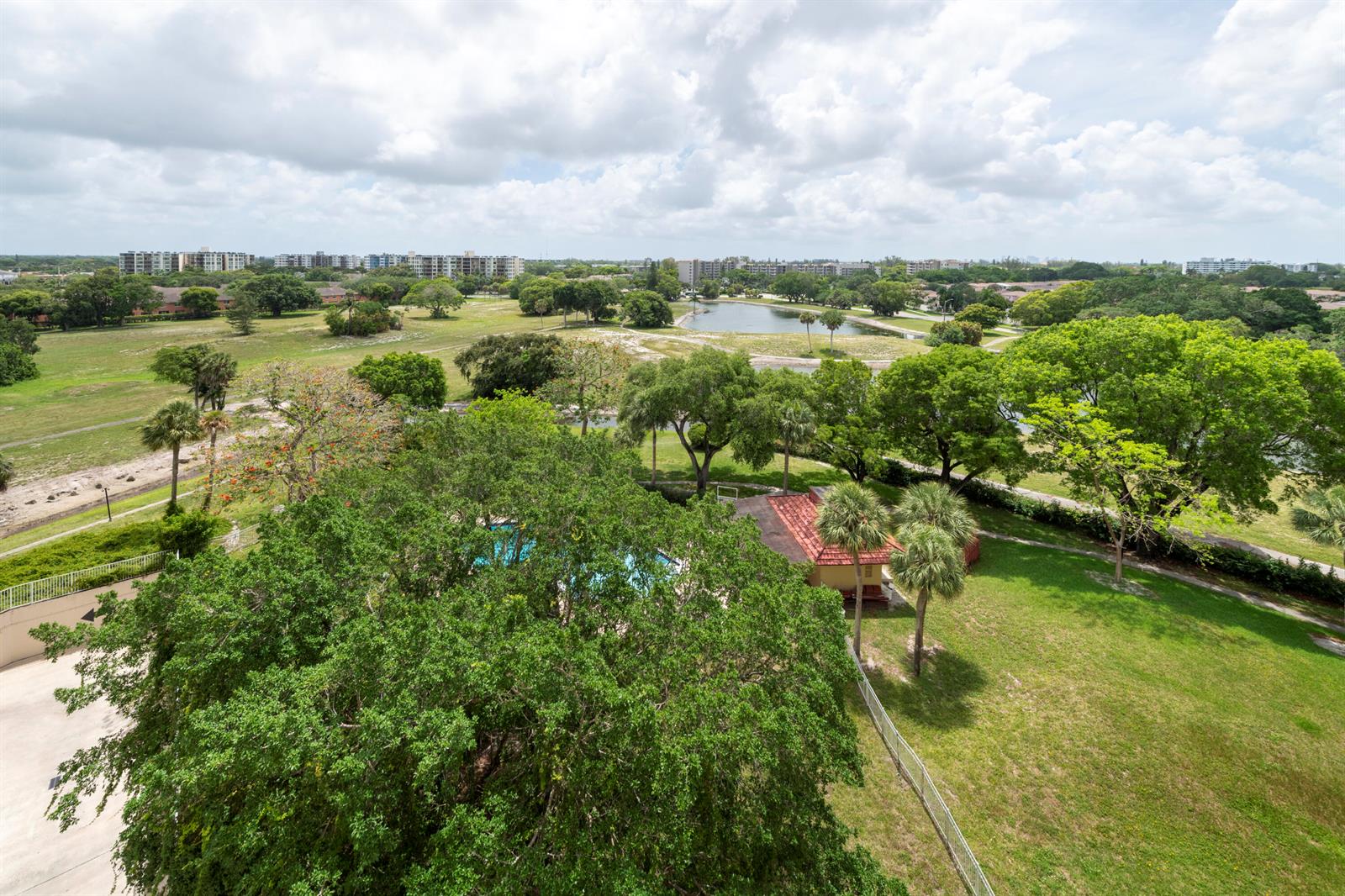 An elevated view of a grassy park with trees, a small pool, and a pond — 6911 Environ Boulevard # 8g, Lauderhill FL 33319, LAUDERHILL, FL