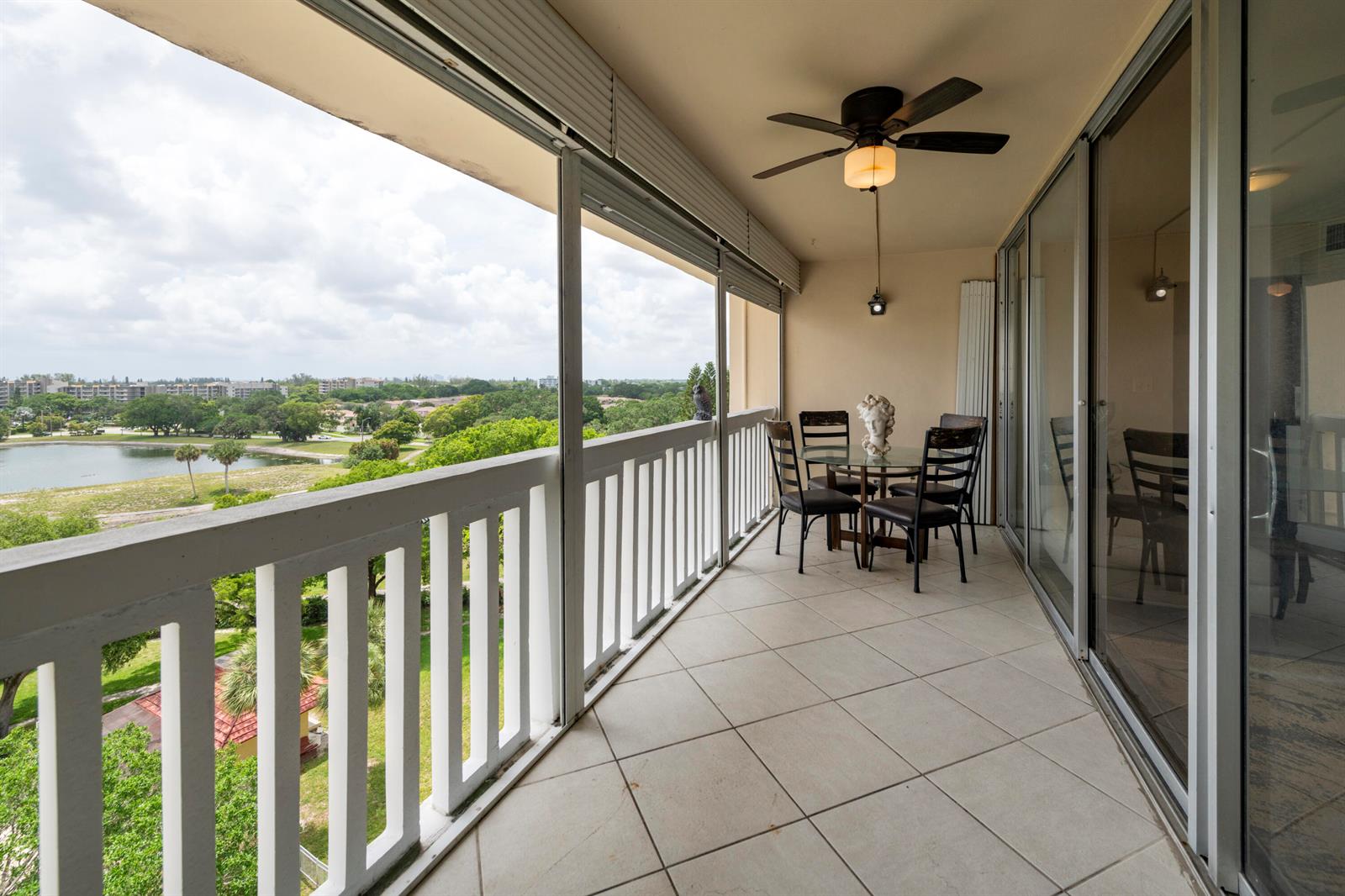 A balcony with tile flooring, a dining set, a ceiling fan, and a lake view — 6911 Environ Boulevard # 8g, Lauderhill FL 33319, LAUDERHILL, FL