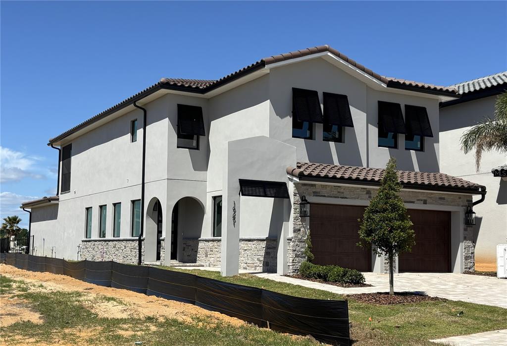 A two-story house with a stucco exterior, stone accents, and a two-car garage — 16251 VETTA DRIVE, BELLA COLLINA, FL