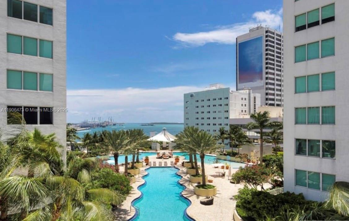An elevated view shows a swimming pool surrounded by palm trees between two apartment buildings — 253 NE 2nd St # 632, Miami FL 33132, MIAMI, FL