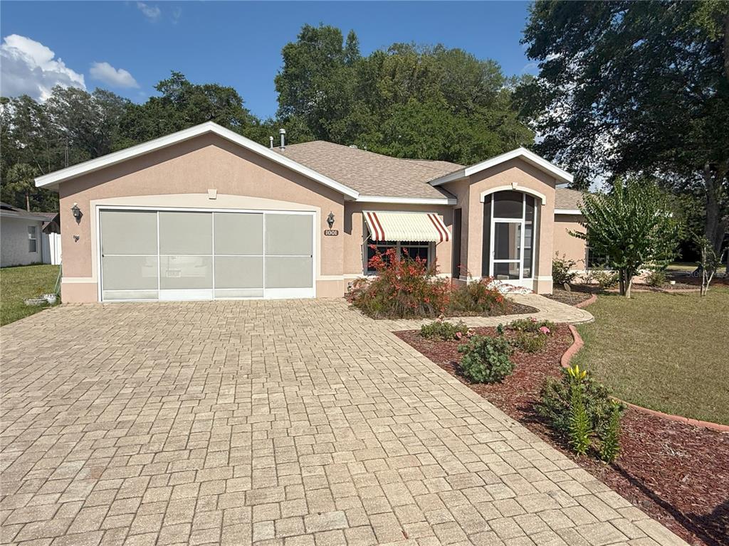A single-story house with a paved driveway, a garage, and a covered entryway — 1001 NE 22ND AVENUE, OCALA, FL