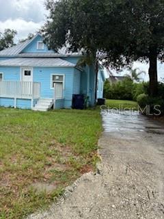 A light blue house with a white porch and a concrete driveway sits on grass — 3110 N MASSACHUSETTS AVENUE, TAMPA, FL