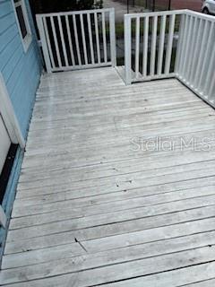 A wooden deck with white railings is attached to the side of a blue house — 3110 N MASSACHUSETTS AVENUE, TAMPA, FL