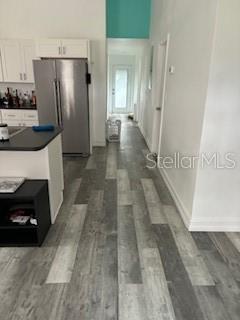A kitchen with white cabinets, a stainless steel refrigerator, and gray wood-look flooring — 3110 N MASSACHUSETTS AVENUE, TAMPA, FL
