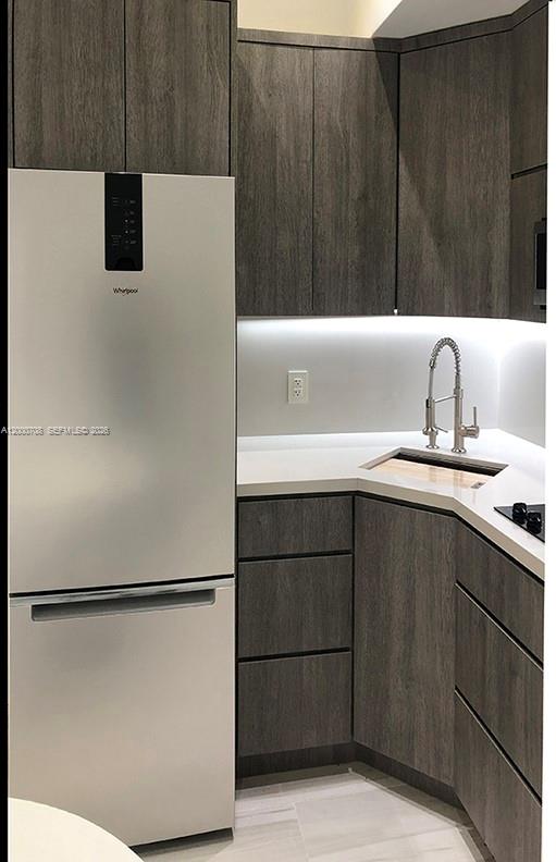 A small kitchen area features a dining table with two chairs and modern gray cabinetry — 1915 Brickell Ave, Miami FL 33129, MIAMI, FL