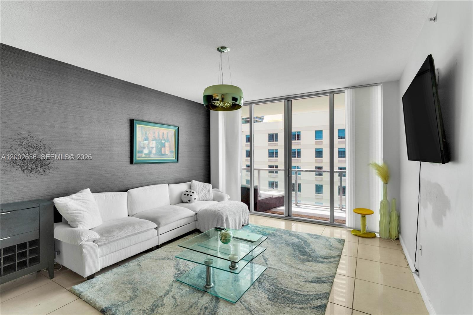 A living room features a white sectional sofa, glass coffee table, and dark accent wall — 79 SW 12th St # 1605, Miami FL 33130, MIAMI, FL