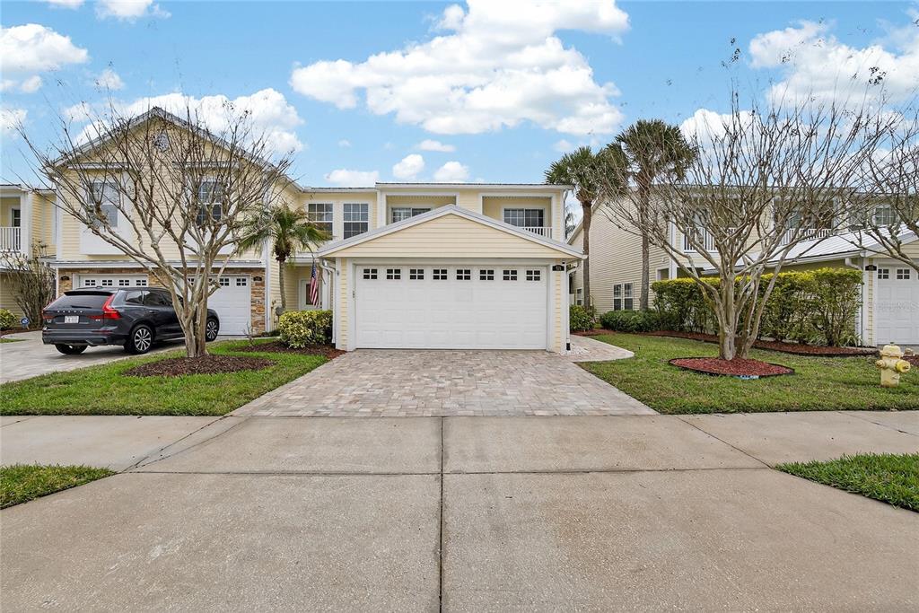 A two-story yellow house with a two-car garage and a paved driveway — 918 WOODBRIDGE COURT, SAFETY HARBOR, FL