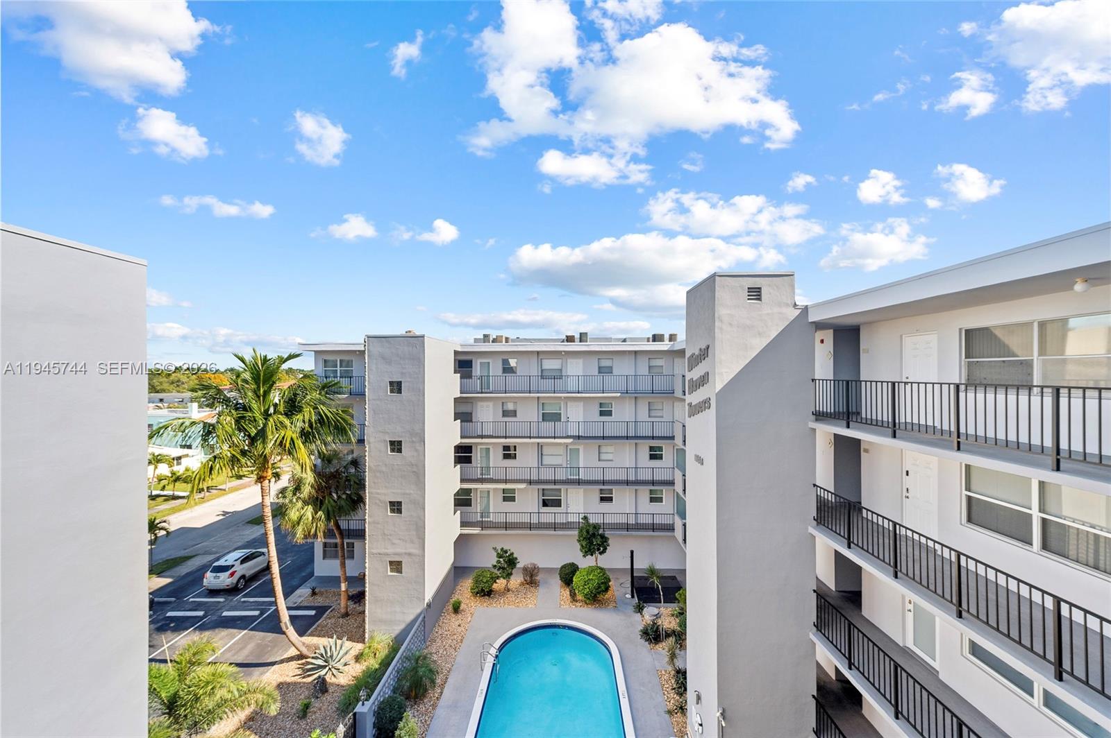 An exterior view shows a multi-story apartment complex with a central swimming pool — 1750 Jefferson St # 510, Hollywood FL 33020, HOLLYWOOD, FL