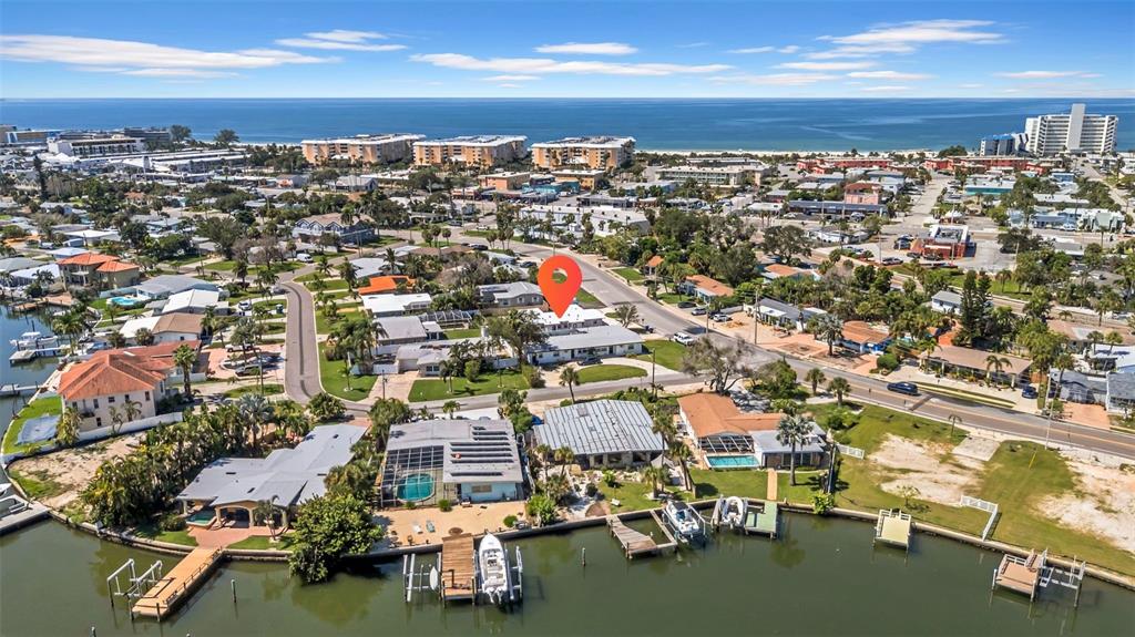 An aerial view shows a waterfront residential property with a boat dock and swimming pool — 6855 GULF WINDS DRIVE, ST PETE BEACH, FL