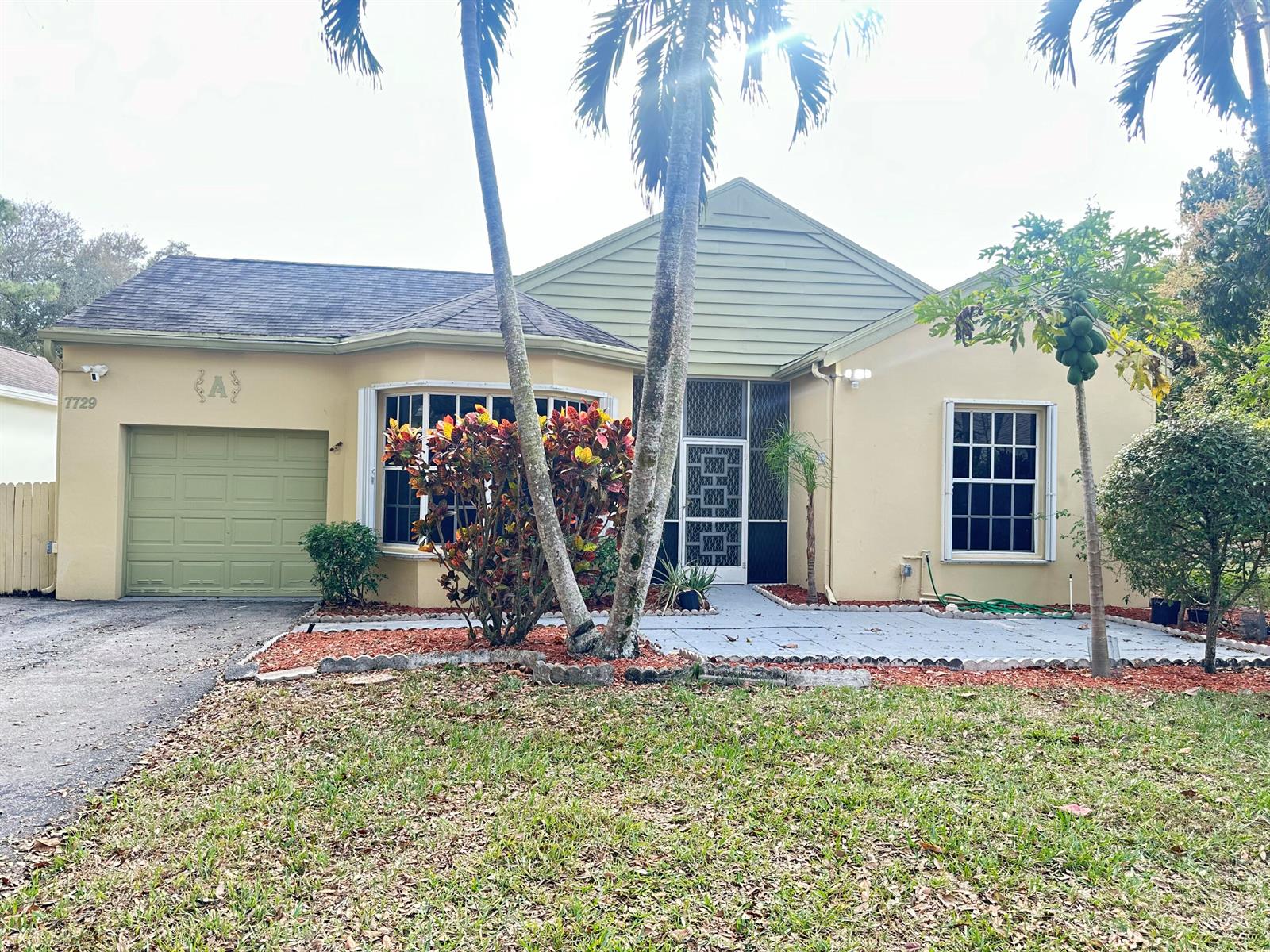 A single-story house with a garage, a bay window, and palm trees in the front yard — 7729 Forest Green Lane, Boynton Beach FL 33436, BOYNTON BEACH, FL
