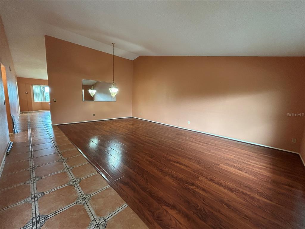A living room features dark wood flooring, peach-colored walls, and a tiled entryway — 2221 NORWEGIAN DRIVE UNIT 57, CLEARWATER, FL