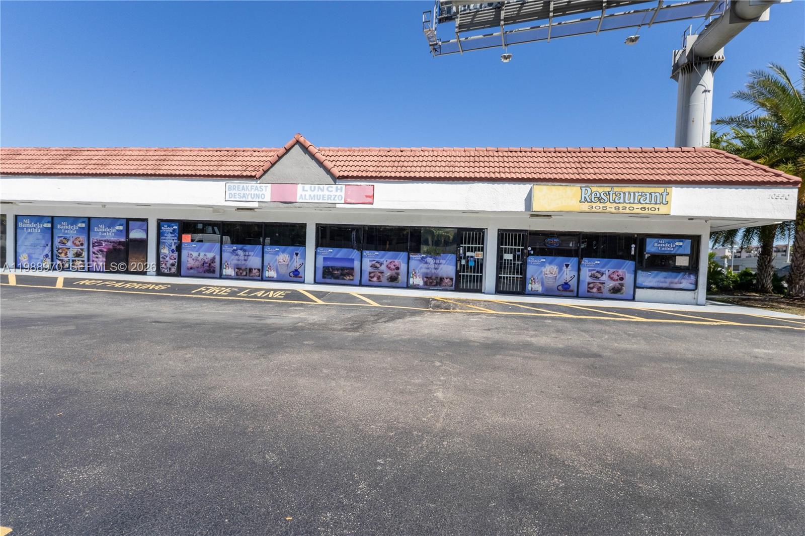 A single-story commercial strip mall building with a tiled roof and a large parking lot — 10550 NW 77 Ct, Hialeah Gardens FL 33016, HIALEAH GARDENS, FL