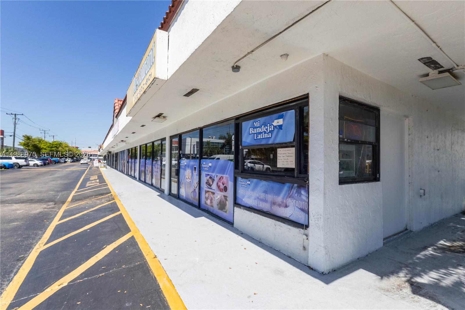 The exterior of a commercial strip mall building features a restaurant with glass storefront windows — 10550 NW 77 Ct, Hialeah Gardens FL 33016, HIALEAH GARDENS, FL