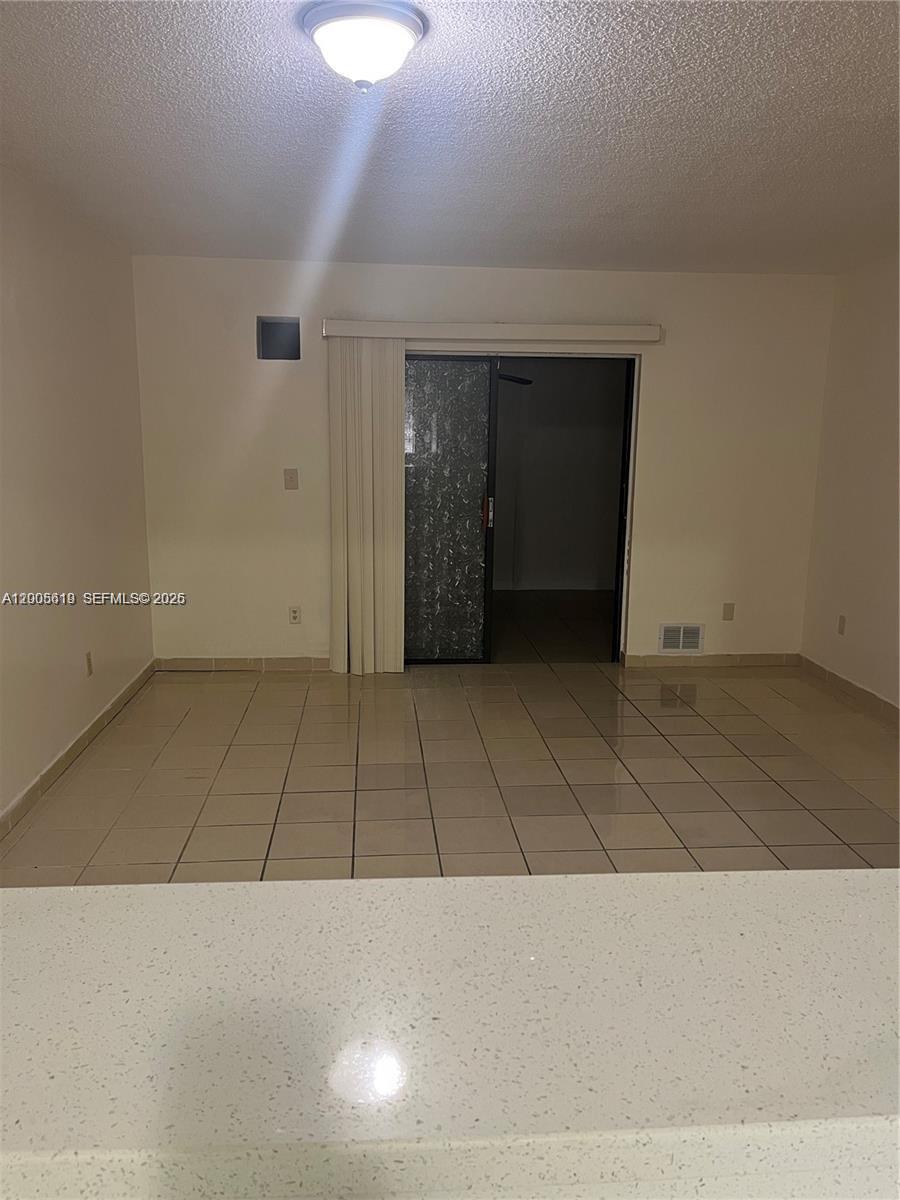 This room features light-colored tile flooring, a sliding glass door, and a ceiling light fixture — 2255 W 55th St # 2, Hialeah FL 33016, HIALEAH, FL