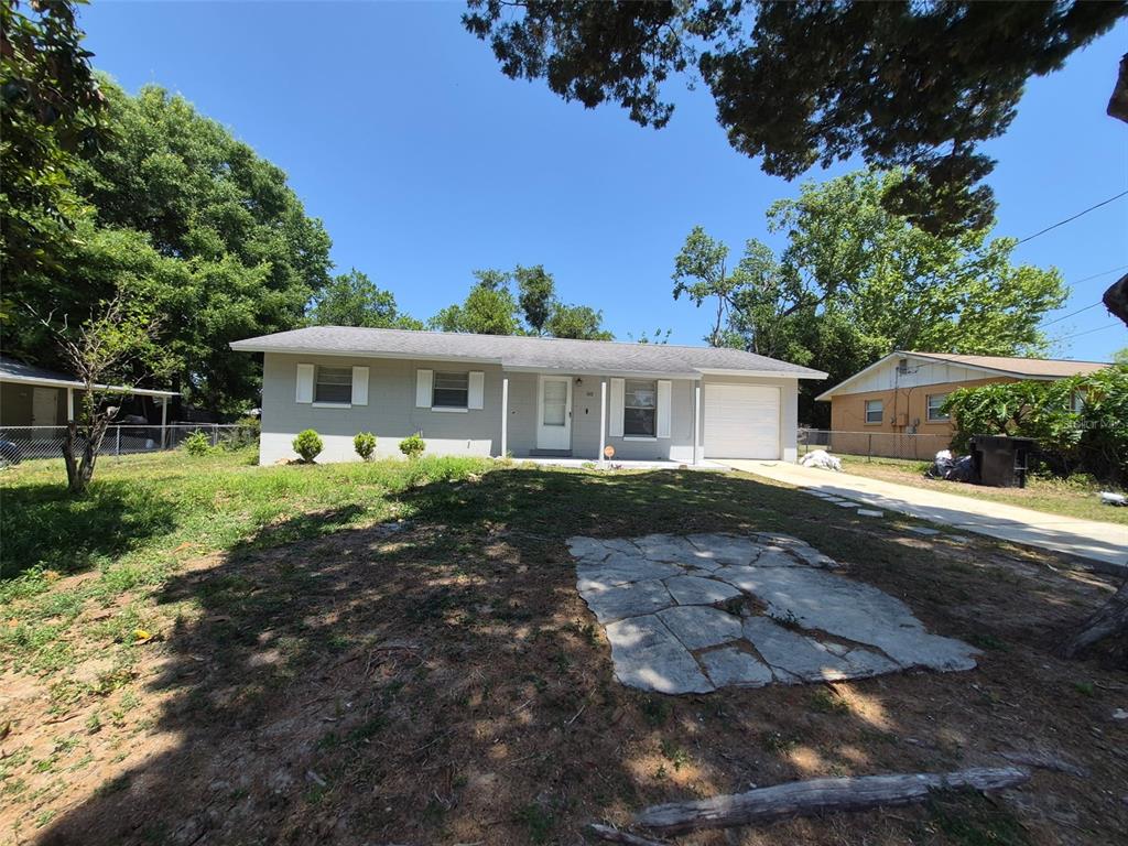A single-story house with a gray exterior, white shutters, and a concrete driveway — 5451 NW 3RD PLACE, OCALA, FL