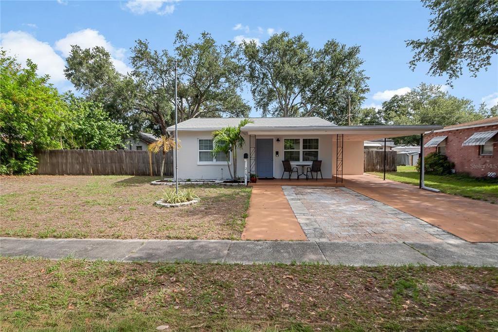 A single-story house with a light-colored exterior, a blue front door, and a paved carport — 2151 44TH AVENUE N, ST PETERSBURG, FL